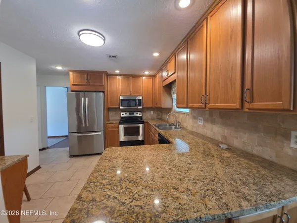 a kitchen with stainless steel appliances granite countertop a sink and cabinets