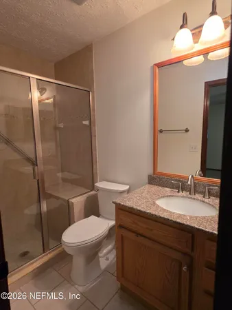 a bathroom with a granite countertop sink toilet a mirror and shower