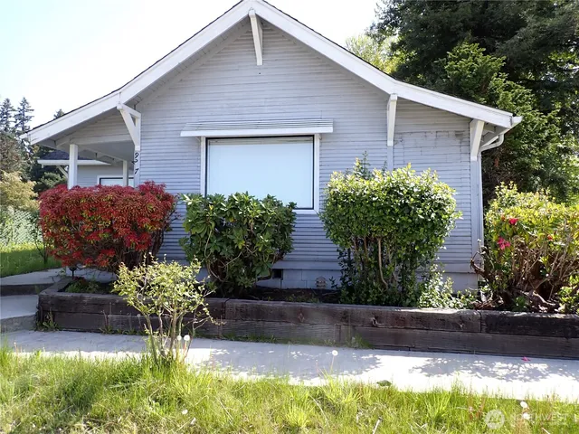 a front view of house with yard and trees in the background