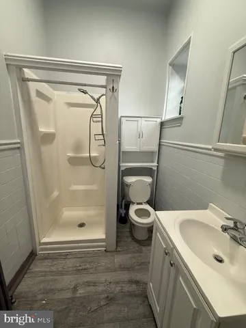 a bathroom with a granite countertop sink toilet and shower