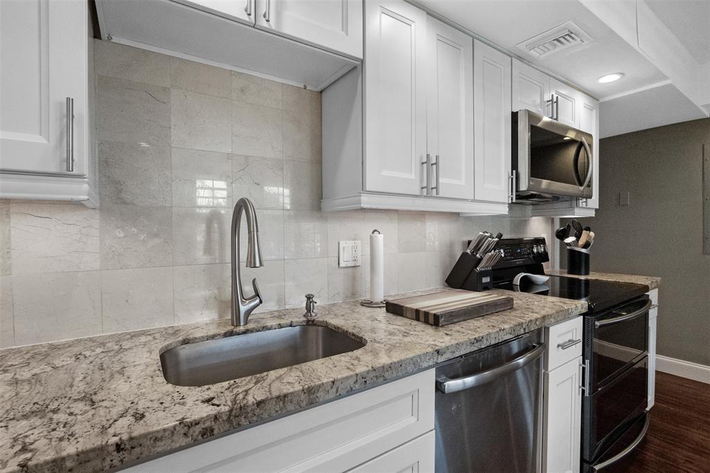 3095 North Course Drive, Unit 203 Pompano Beach, FL 33069 - Photo 17 of 49 a kitchen with granite countertop a sink a stove and cabinets