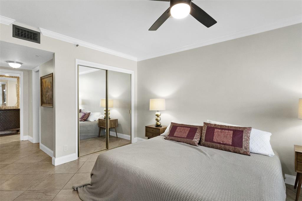 3095 North Course Drive, Unit 203 Pompano Beach, FL 33069 - Photo 28 of 49 a bed room with a bed and a chandelier