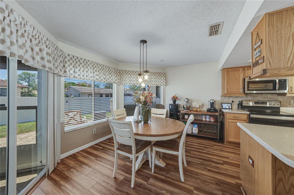 7435 Kilbride Court Weeki Wachee, FL 34613 - Photo 13 of 67 a dining room with furniture a chandelier and wooden floor