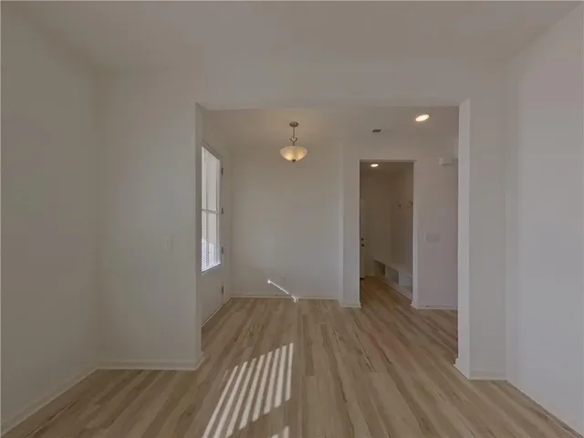 a view of a room with wooden floor and a ceiling fan