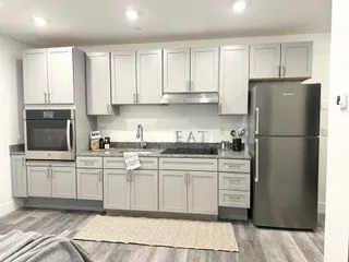 a kitchen with granite countertop a refrigerator sink and cabinets
