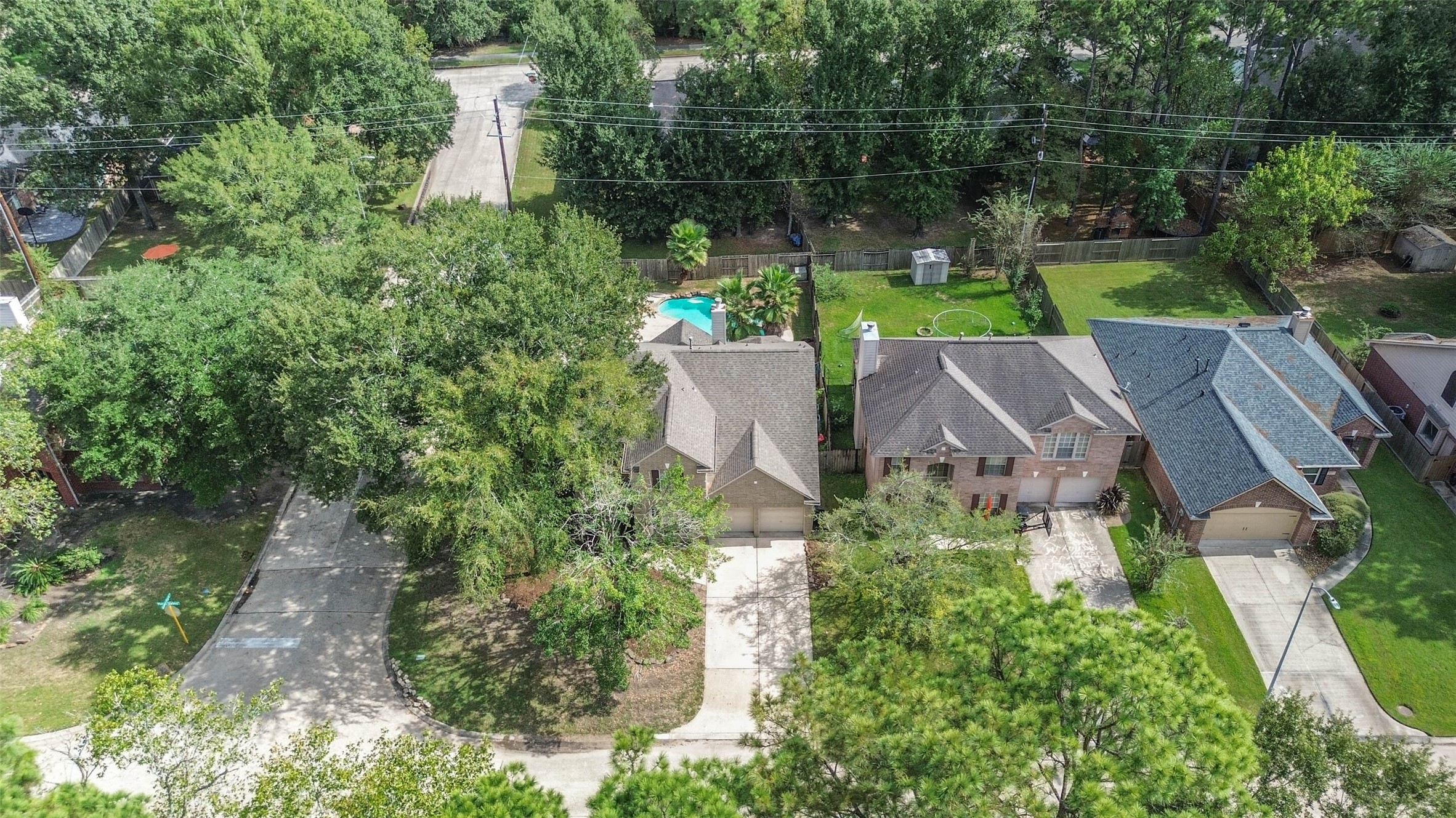 6338 Maple Spring Place Humble, TX 77346 - Photo 49 of 50 Enjoy a neighborhood landscape filled with mature trees, with your own pool waiting at home. This aerial perspective highlights the corner setting and the blend of leafy surroundings and backyard recreation.