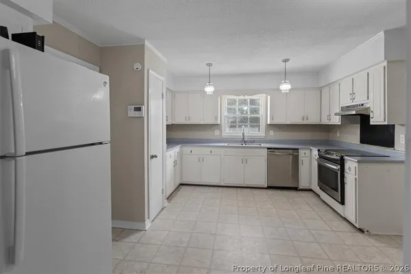 a kitchen with a sink refrigerator and cabinets