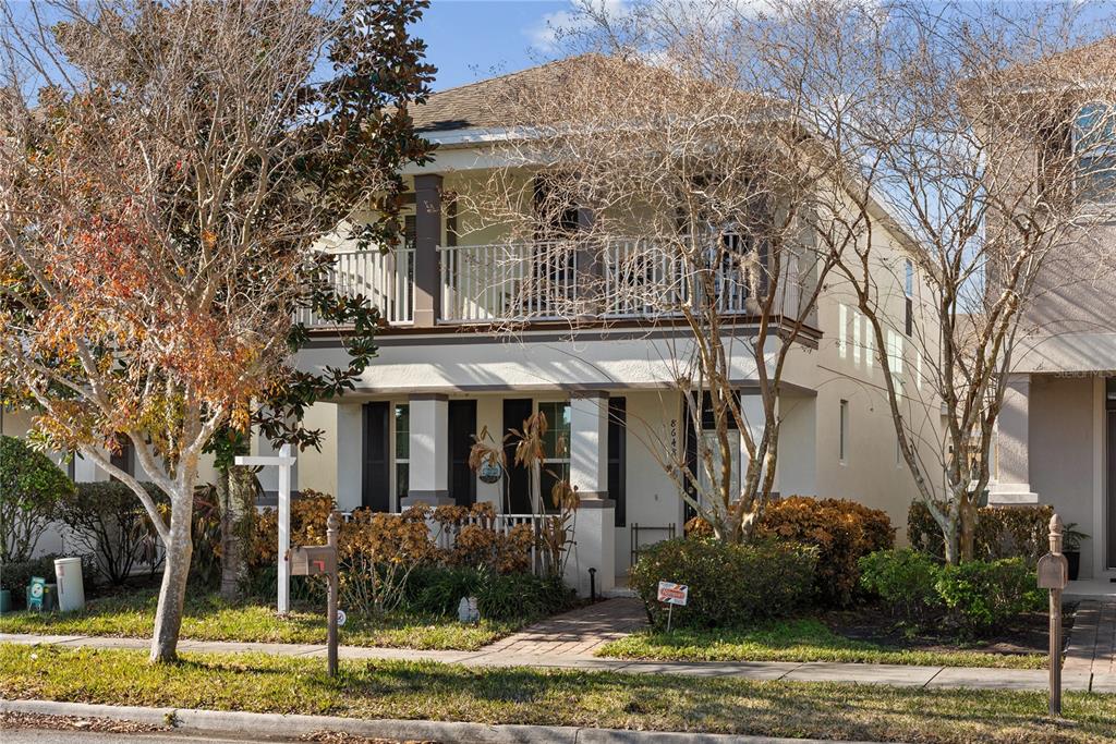 a view of a big house with large trees and plants