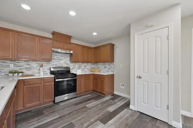 a kitchen with granite countertop stainless steel appliances and wooden cabinets