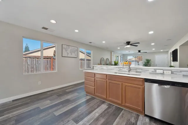 a kitchen with granite countertop a sink and dishwasher with wooden floor