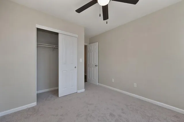 an empty room with a ceiling fan and a window