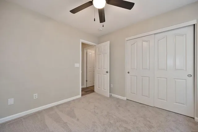 an empty room with chandelier fan