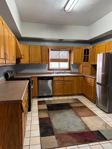 a front view of a house with a yard covered in snow