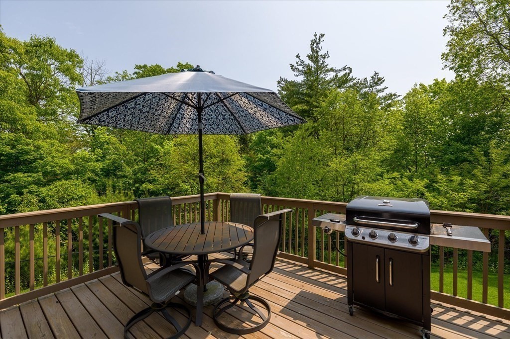 15 Tannery Road Sturbridge, MA 01518 - Photo 32 of 41 a view of a roof deck with table and chairs under an umbrella with wooden floor