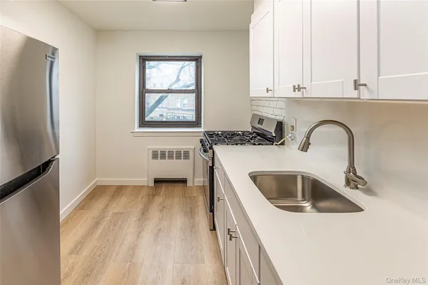 a kitchen with a sink a refrigerator and cabinets