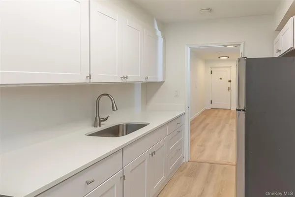 a kitchen with granite countertop white cabinets and a sink