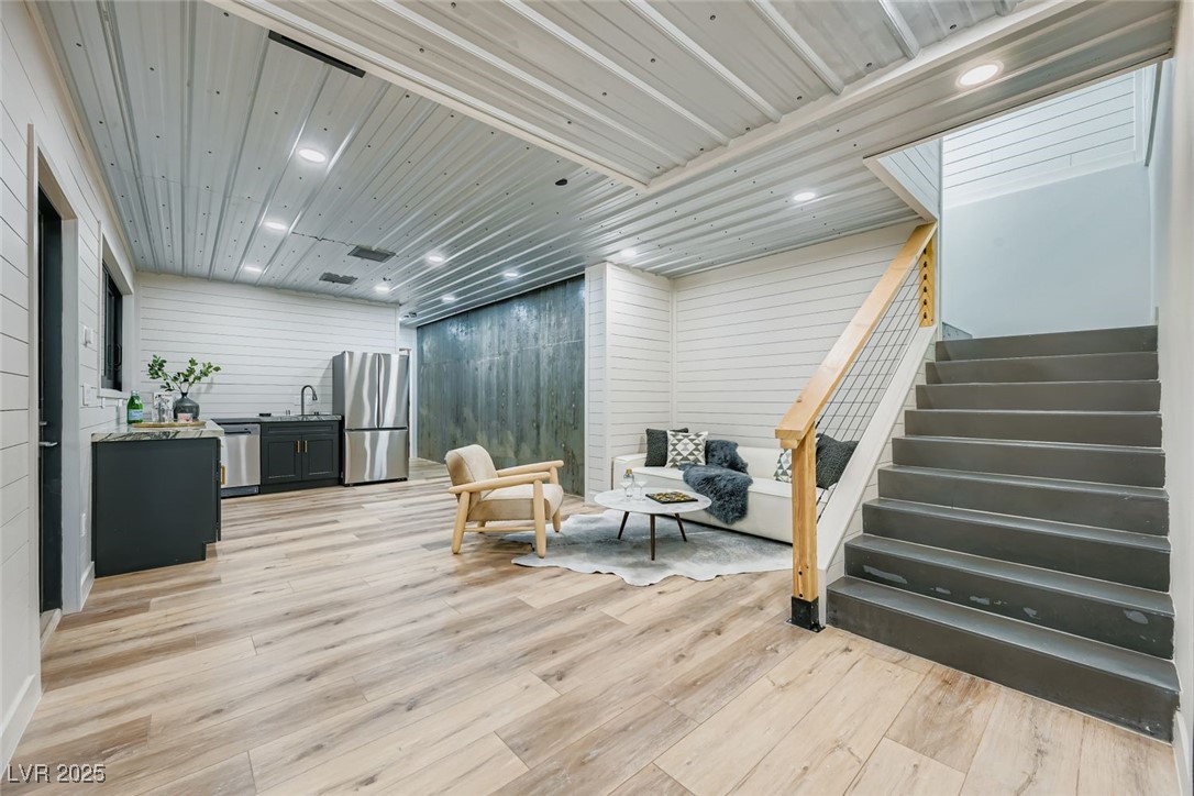 4096 Tyrol Way Mount Charleston, NV 89124 - Photo 20 of 50 The downstairs suite offers a complete seperate area for guests, parties, gatherings or children, and is secluded space from the main room. This bottom floor includes a kitchenette, with refrigerator, sink, dishwasher, and is a great space for watching tv, lounging, or hosting parties. the open space offers ability to put mobile bar, or island, and pass through sliding window opens to the outdoor downstairs party deck, featuring a hot tub, 2nd wood burning fireplace and amazing connection to the forest.