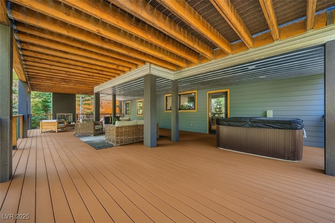 4096 Tyrol Way Mount Charleston, NV 89124 - Photo 23 of 50 Perfect for gatherings, parties, or hitting the hot tub, the downstairs party deck features a second woodburning fireplace, and large sitting area. The pass through sliding window opens into the kitchen, to facilitate food and drink.