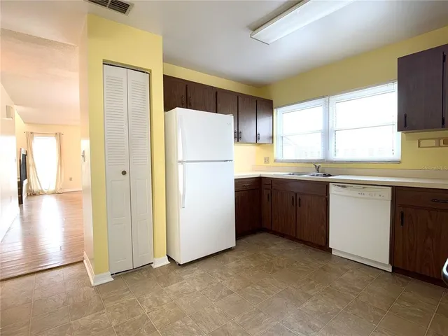 a kitchen with a refrigerator sink and cabinets