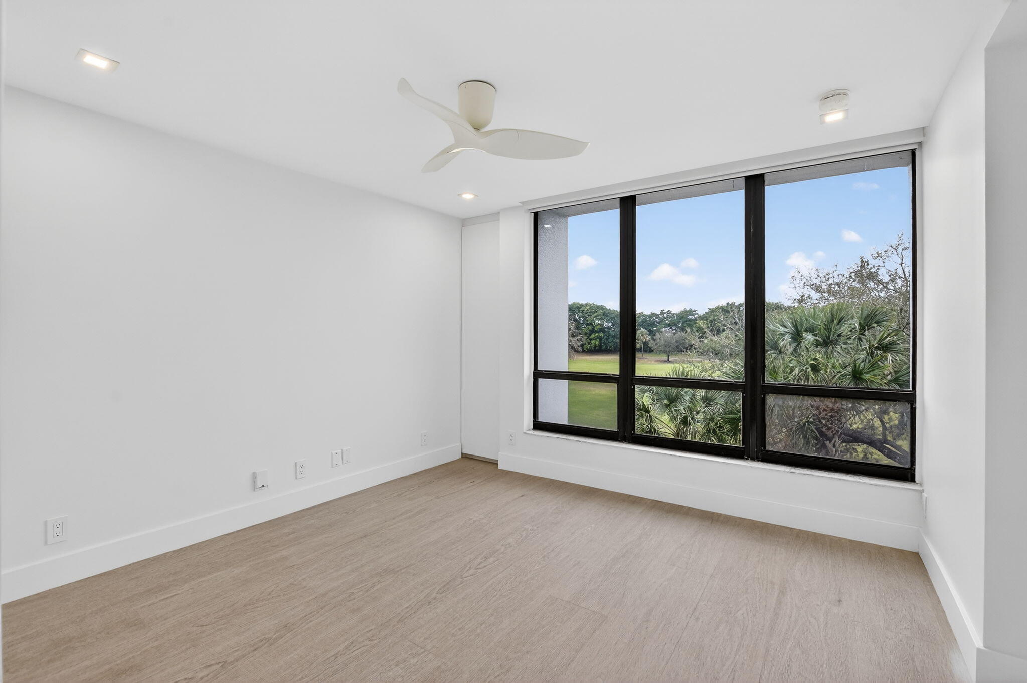 7835 Lakeside Boulevard, Unit 946 Boca Raton, FL 33434 - Photo 17 of 20 an empty room with wooden floor and windows