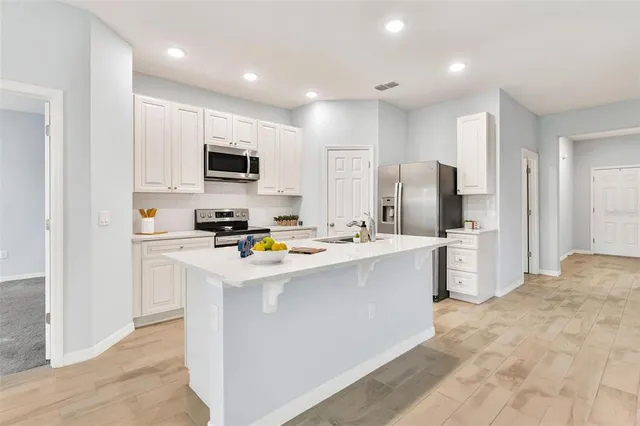 a kitchen with stainless steel appliances a refrigerator stove microwave and sink