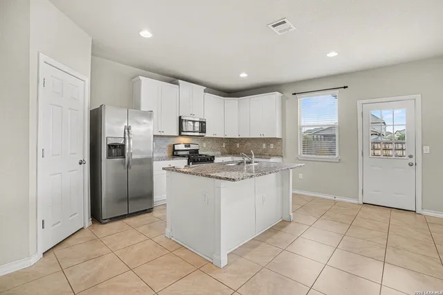a kitchen with stainless steel appliances granite countertop a refrigerator and a sink