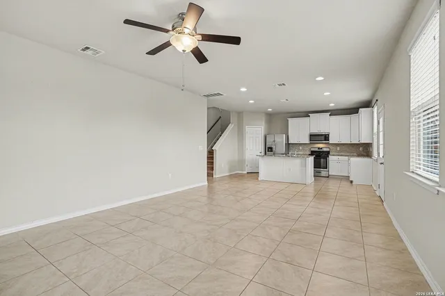 a view of kitchen with cabinets and window