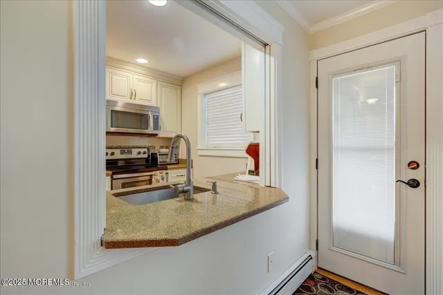 a kitchen with stainless steel appliances granite countertop a granite counter tops and a view of living room
