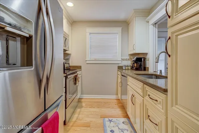 a kitchen with stainless steel appliances granite countertop a refrigerator and a stove