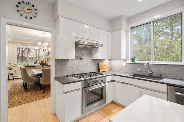 a kitchen with stainless steel appliances granite countertop a sink stove and cabinets
