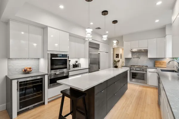 a large kitchen with kitchen island a stove a sink a refrigerator and a microwave