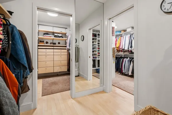 a view of walk in closet with clothes and shoes
