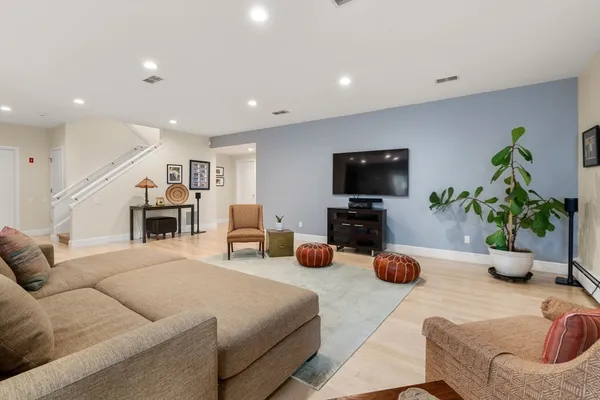 a living room with furniture a flat screen tv and a potted plant