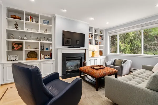 a living room with furniture a flat screen tv and a fireplace