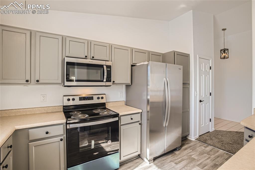 3764 Riviera Grove, Unit 203 Colorado Springs, CO 80922 - Photo 21 of 31 a kitchen with stainless steel appliances and white cabinets
