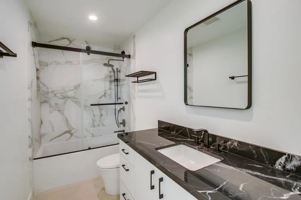 14066 Crest Way Del Mar, CA 92014 - Photo 21 of 32 a bathroom with a granite countertop sink toilet a mirror and shower