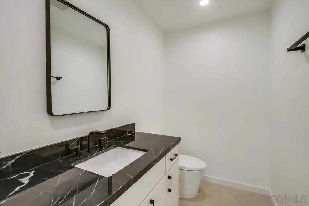 14066 Crest Way Del Mar, CA 92014 - Photo 24 of 32 a bathroom with a granite countertop toilet sink and mirror