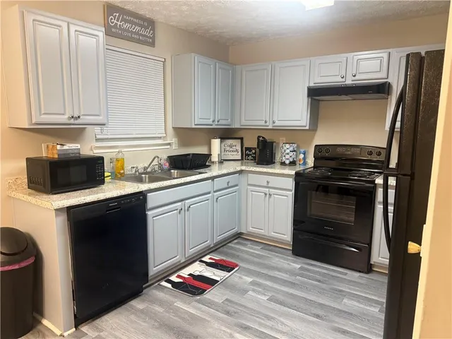 a kitchen with white cabinets and appliances