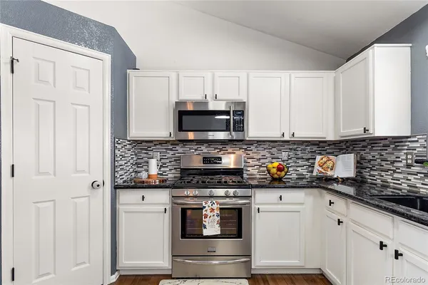 a kitchen with stainless steel appliances a stove a microwave and cabinets