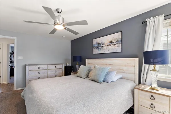 a spacious bedroom with a bed and a chandelier