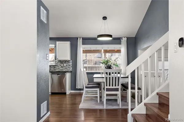 a kitchen with a refrigerator and wooden floor