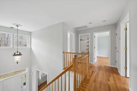 a view of a hallway with wooden floor and staircase