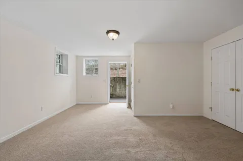 a view of an empty room with closet and a window