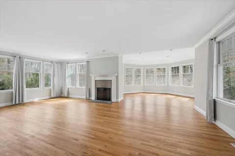 a view of empty room with wooden floor and fireplace