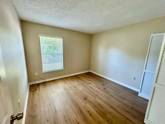 a view of a room with wooden floor and a window