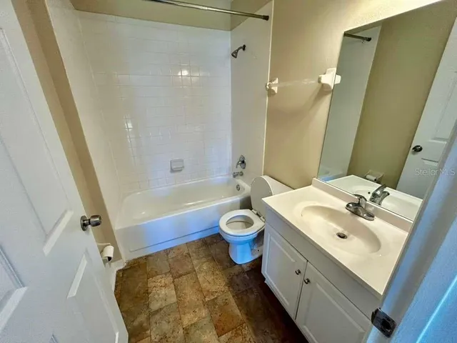 an empty room with wooden floor and a ceiling fan