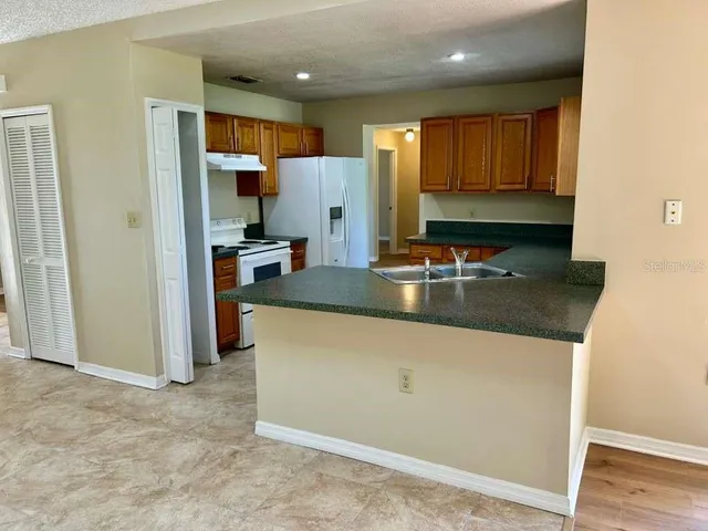 a kitchen with stainless steel appliances granite countertop a refrigerator and a stove
