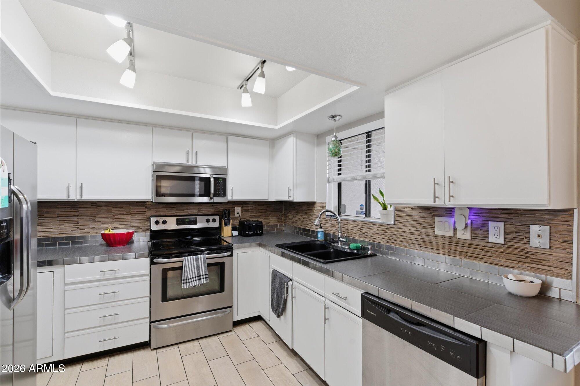 3635 North 37th Street, Unit 10 Phoenix, AZ 85018 - Photo 12 of 26 a kitchen with stainless steel appliances a stove a sink and cabinets
