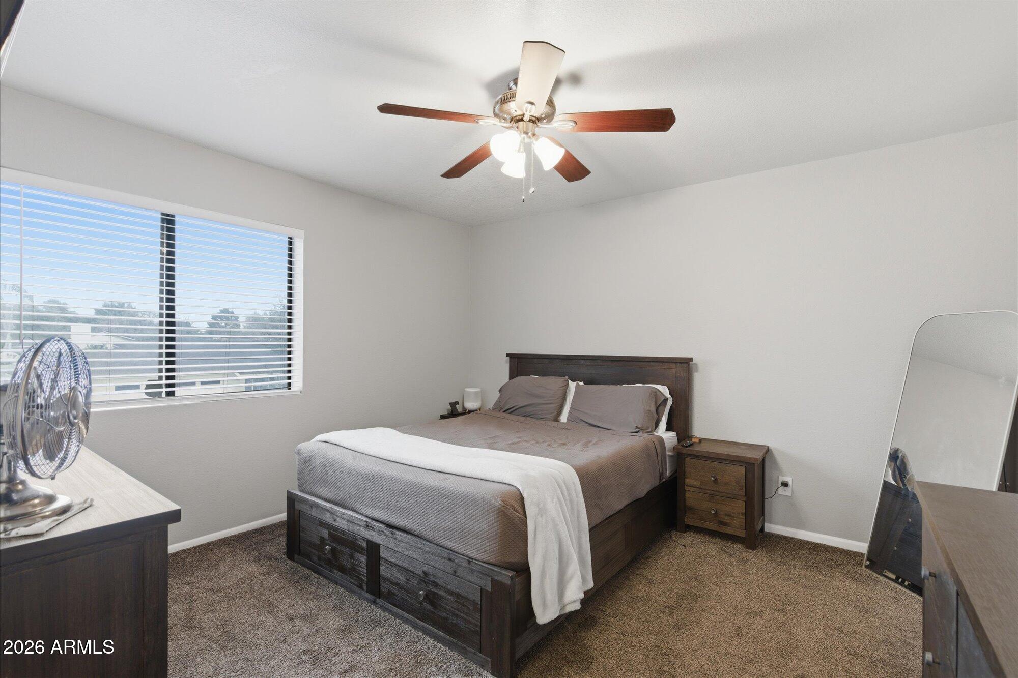 3635 North 37th Street, Unit 10 Phoenix, AZ 85018 - Photo 16 of 26 a bedroom with a bed and a chandelier