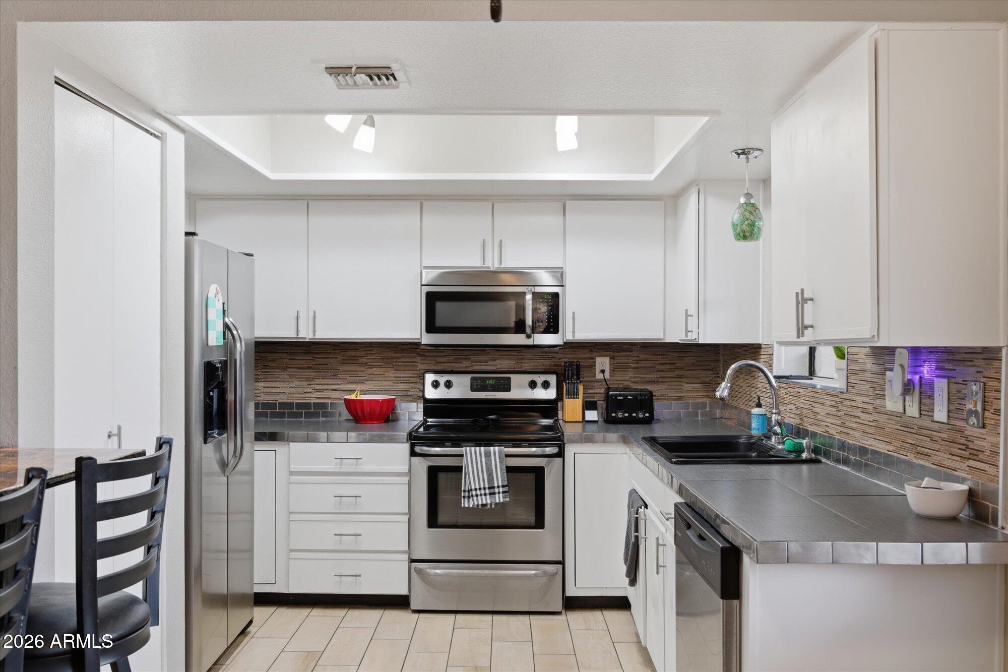 3635 North 37th Street, Unit 10 Phoenix, AZ 85018 - Photo 9 of 26 a kitchen with stainless steel appliances granite countertop a stove and a sink